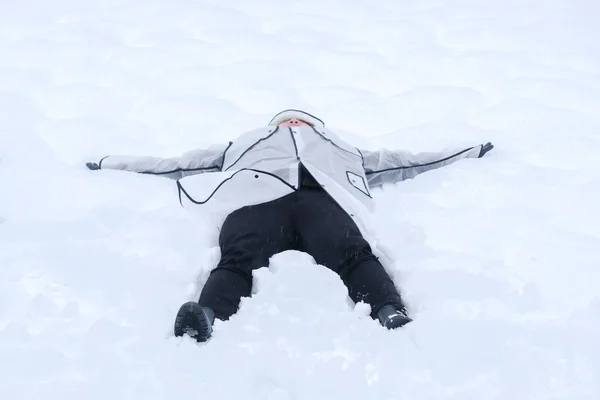年轻人躺在冰冻的雪地上 在一个阳光灿烂的寒假里玩冬奥会 — 图库照片