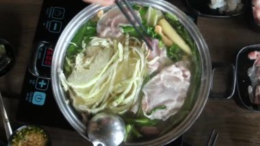 Manzara, Asya Shabu Shabu ya da Sukiyaki 'nin taze yemeklerini yemekten sıcak haşlama çorbada sebzeli çiğ etle restoranda pişirmekten hoşlanıyor.