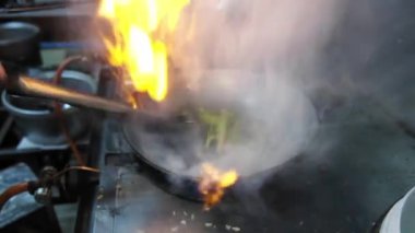 Şef, yemek hazırlıyor. Kızarmış su mimozasını kırmızı biberle karıştırıyor. Mutfak restoranında tavada kızarıyor. .
