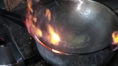Şef, yemek hazırlıyor. Kızarmış su mimozasını kırmızı biberle karıştırıyor. Mutfak restoranında tavada kızarıyor. .
