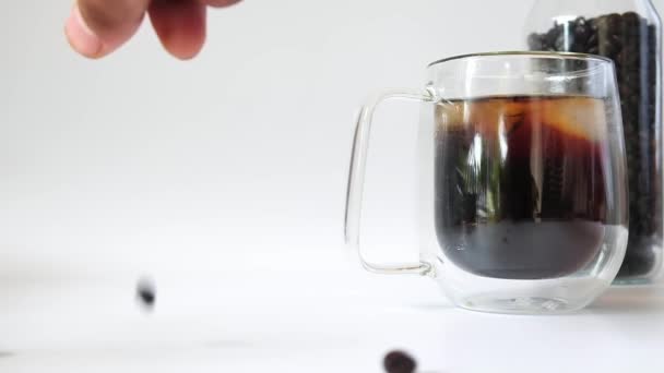 Close Caffè Nero Tazza Trasparente Chicchi Caffè Torrefatto Cadere Isolato — Video Stock