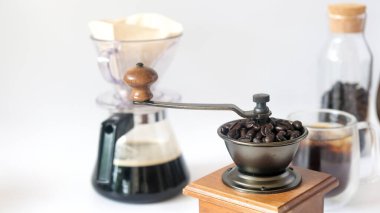 Kahve seti, el değirmeni el değirmeni kahve öğütücüsünde kavrulmuş kahve çekirdekleri ve cam şişe siyah kahve kağıdı.