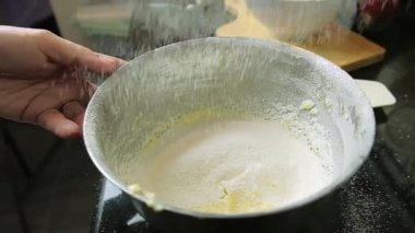 Yavaş çekimde un, klozete dökülen elek, içindekiler ve mutfakta kek pişirme hazırlığı aşamaları, un, kar yağışına benzer.