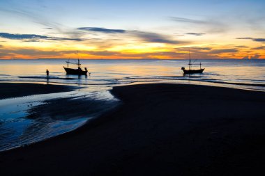 Güneşin doğuşunun güzel manzarası. Sahilde siluet balıkçı teknesi, Tayland 'da turuncu ve mavi gökyüzü. 