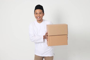 Karton kutu taşıyan Koko gömlekli heyecanlı Asyalı Müslüman adamın portresi. Bayram için eve gidiyorum. Beyaz arkaplanda izole edilmiş resim