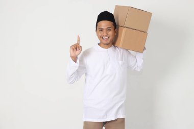 Koko gömlekli heyecanlı Asyalı Müslüman adamın portresi. Yanında karton kutu taşıyordu. Bayram için eve gidiyorum. Beyaz arkaplanda izole edilmiş resim