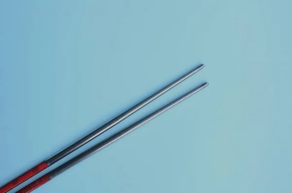 Mavi arka planda yemek çubukları