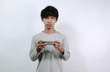 Asyalı adamlar gri uzun kollu tişörtler giyiyorlar. Asyalı adamın gözleri parladı.