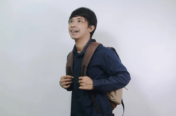 明るい表情の若い男 青いシャツを着て白い背景に孤立したバッグを持っている若いアジア人男性 — ストック写真