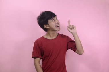 Erkekler yukarı bakarken fikirleri düşünürler. Kırmızı tişört giyen Asyalı adamlar pembe arka planda izole edilmiş.