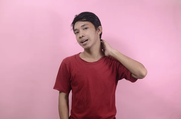 Happy face of funny good looking Asian man. Asian men wearing red t shirts isolated on a pink background