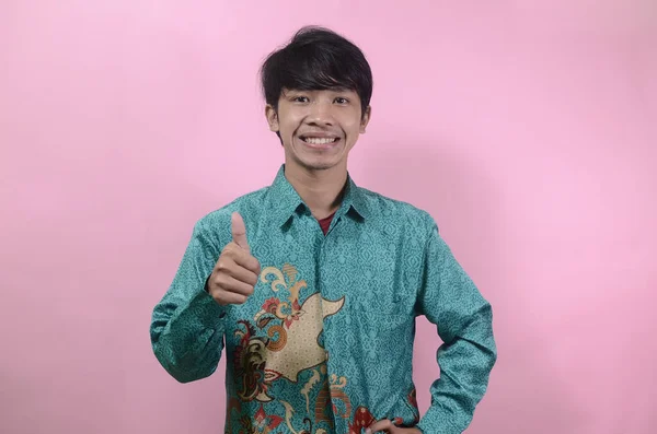Ελκυστικός Νεαρός Ασιάτης Που Φοράει Πουκάμισο Μπατίκ Χαμογελώντας Και Δείχνοντας — Φωτογραφία Αρχείου