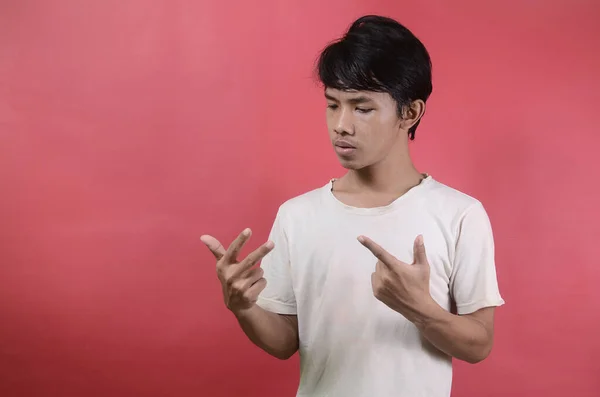 Parmaklarıyla sayan adam. Kırmızı arka planda beyaz tişörtler giyen Asyalı adamlar. 