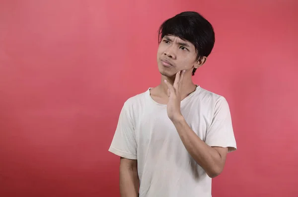 Kafası Karışmış Asyalı Genç Bir Adam Kırmızı Arka Planda Beyaz — Stok fotoğraf