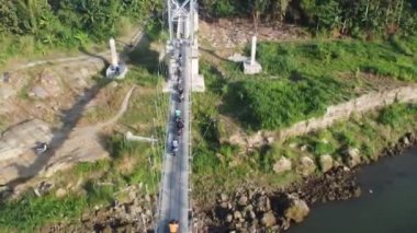 Yogyakarta, Endonezya - 08 Temmuz 2020: Asma köprüden geçen köylülerin hava görüntüsü. Yogyakarta Endonezya
