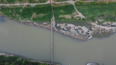 Nehirdeki bambu köprüsünün üst görüntüsü.