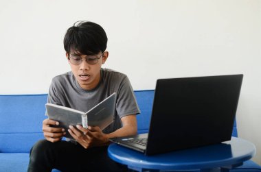 Asyalı adam kanepede oturmuş işiyle meşguldü.