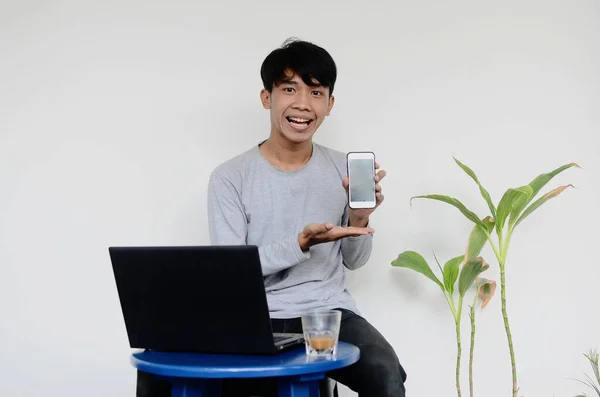 Fiatal Ázsiai Férfi Aki Laptop Előtt Miközben Mutatja Mobilját — Stock Fotó