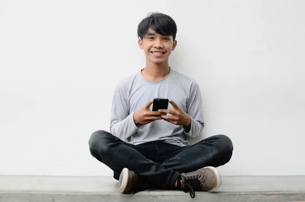 Cep telefonu kullanan mutlu bir Asyalı adamın portresi.