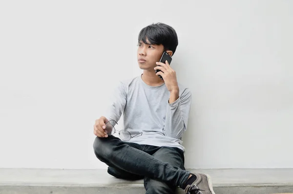 Ασιάτης Νεαρός Που Κάθεται Και Μιλάει Στο Τηλέφωνο — Φωτογραφία Αρχείου