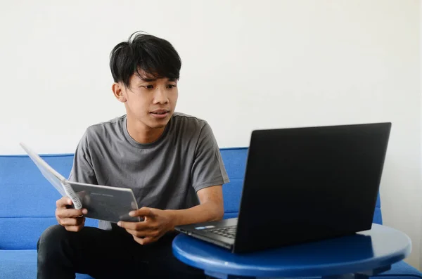 Asyalı adam kanepede oturmuş işiyle meşguldü.