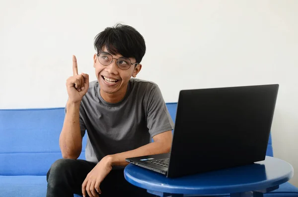 Joven Hombre Asiático Sentado Sofá Delante Computadora Portátil Con Una —  Fotos de Stock