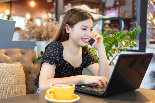 Mutlu kadınlar tatilde bir kafede telefon ve defterle bilgi istiyorlar.