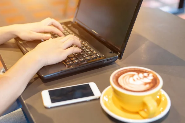 Dizüstü bilgisayarda çalışan eller. 