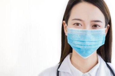 Doktor kadın koronavirüsü korumak için maske takıyor.