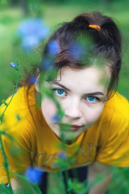 Genç ve güzel bir kız yazın çiçeklerle dolu bir tarlada dinleniyor. # Yeşil çimlerde esmer #