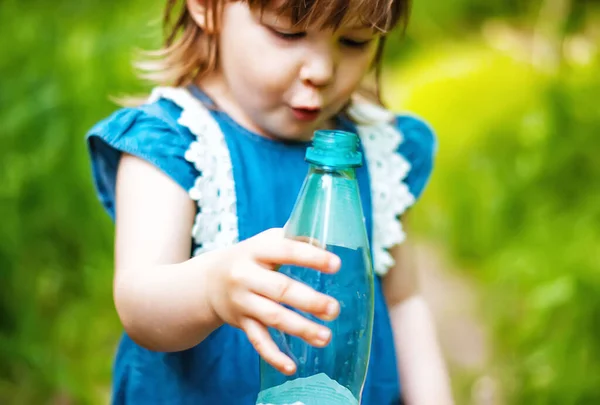 Милая Маленькая Девочка Держит Пустую Пластиковую Бутылку Свежем Воздухе Природе — стоковое фото