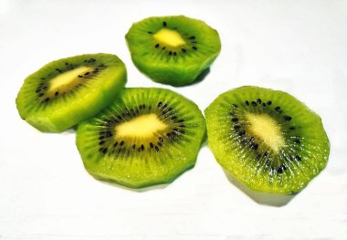 Yeşil kivi dilimleri masanın üstünde. Tropikal kivi meyvesi