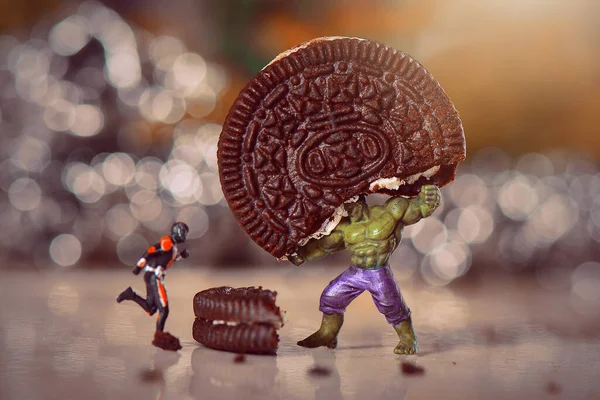 Minyatür figür Hulk 'un karıncalarla savaşan bisküvileri kaldırdığını düşün.