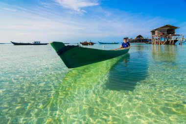 Tekne, Bintan Adası 'ndaki balıkçı köyünde berrak suyun üzerinde süzülürken, gündüz çekilmiş fotoğraflar, Pengudang plajı, Trikora plajı..