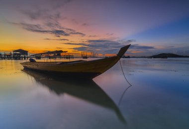 Güzel gün batımı ve balıkçı köyü Batam Adası 'nda geleneksel tekne.