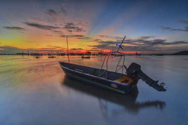 Güzel gün batımı ve balıkçı köyü Batam Adası 'nda geleneksel tekne.