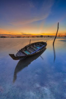 Güzel gün batımı ve balıkçı köyü Batam Adası 'nda geleneksel tekne.