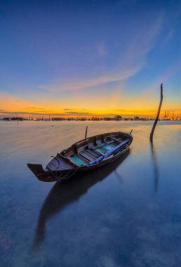 Güzel gün batımı ve balıkçı köyü Batam Adası 'nda geleneksel tekne.