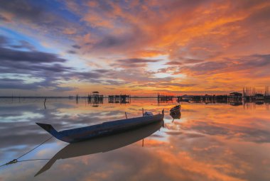 Güzel gün batımı ve balıkçı köyü Batam Adası 'nda geleneksel tekne.