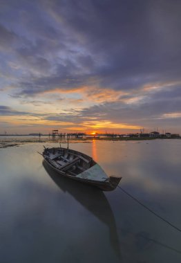 Güzel gün batımı ve balıkçı köyü Batam Adası 'nda geleneksel tekne.