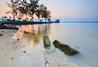 Ocarina Sahili Batam Adası 'nda güzel bir gün batımı ve geleneksel tekne balıkçısı.