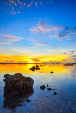 Ocarina Sahili Batam Adası 'nda güzel bir gün batımı ve geleneksel tekne balıkçısı.