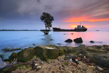 Günbatımında Tanker Gemisi Batam Adası 'nda, kayalarda yosun