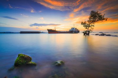 Günbatımında Tanker Gemisi Batam Adası 'nda, kayalarda yosun