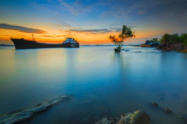 Günbatımında Tanker Gemisi Batam Adası 'nda, kayalarda yosun