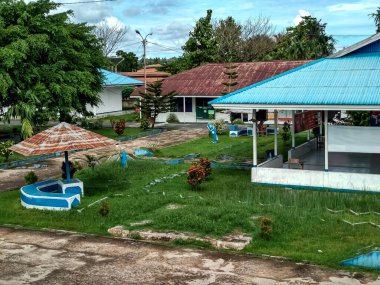 Mavi gökyüzü ve yeşil çimenleri olan güzel bir bina.