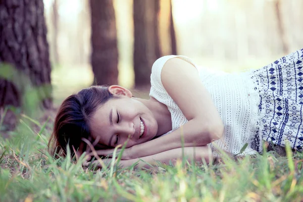 快乐的年轻亚洲女人躺在公园的草地上 用古色古香的色调 — 图库照片