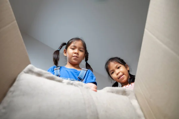 両親を助ける2人のアジア系の子供の女の子は 移動中の日に箱に物を入れました 住宅改修と移転のコンセプト — ストック写真