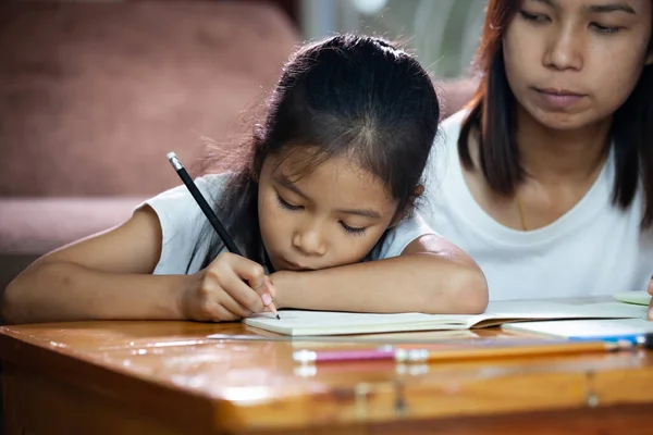 Молода Азіатська Мати Допомагає Доньці Робити Домашнє Завдання Вдома Освіта — стокове фото
