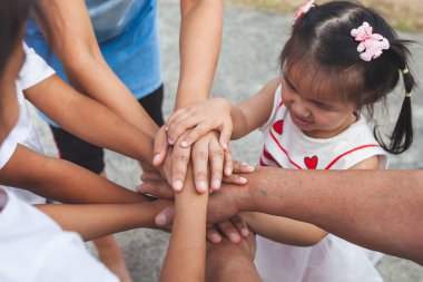 Asyalı aile el ele tutuşup destek oluyor. Aile nesli birlik ve takım çalışmasını göstermek için el ele tutuşur.